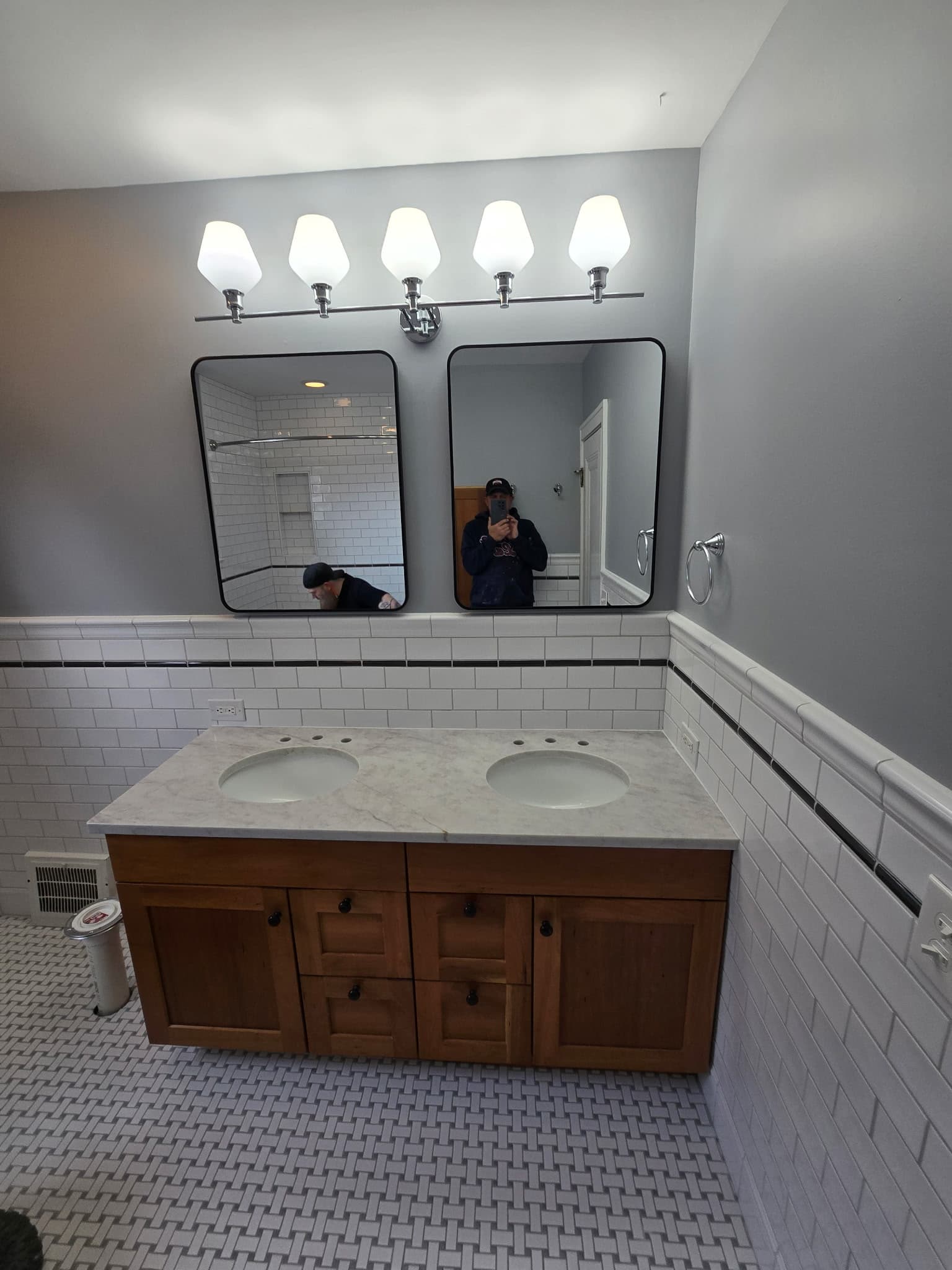 Classic bathroom remodel with double wood vanity, marble counter, and twin black-framed mirrors by 8 Is Enough Construction Lorain County OH